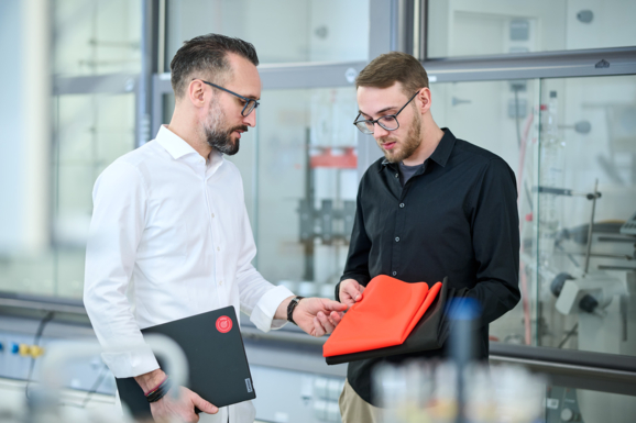 Zwei Personen im Labor prüfen Gewebe und unterhalten sich