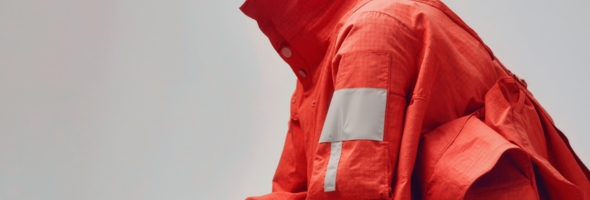 Rotes Gewebe mit reflektierenden Elementen für hohe Sichtbarkeit.