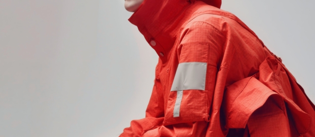 Rotes Gewebe mit reflektierenden Elementen für hohe Sichtbarkeit.